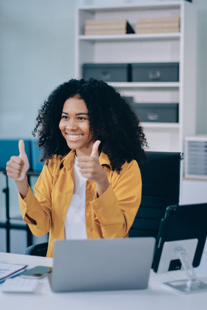 Pretty female freelancer working on laptop while sitting on modern coworking background