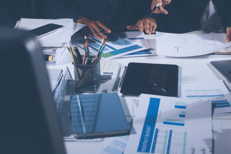 Professional photo of a person's hands reviewing a contract or legal document on a desk, for...