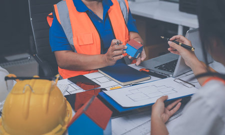 engineer and an architect reviewing blueprints and construction plans together