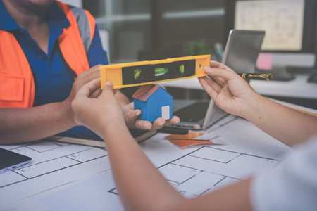 engineer and an architect reviewing blueprints and construction plans together