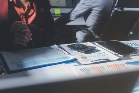 business people or accountant using calculator while working analytical business report on the...