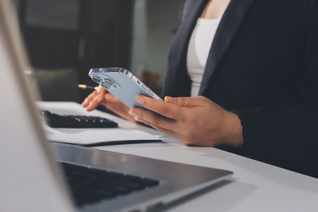 Auditors collaborating in modern office, analyzing financial documents and using calculator with a...