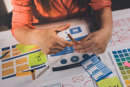 team of UI UX web designer are working together to develop mobile responsive websites with UI UX front end designer previewsの写真素材