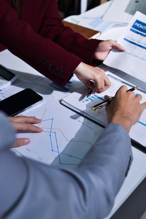 Business people analyzing monthly budget and financial report using data and chart to strategize and...