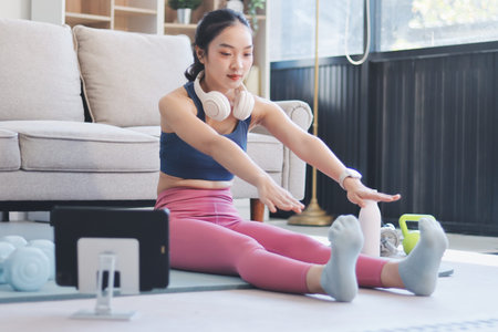 Young Asian sporty attractive woman practicing yoga at home.