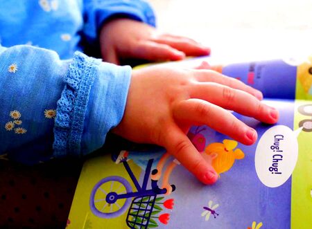 The hands of a children who is reading a bookの写真素材