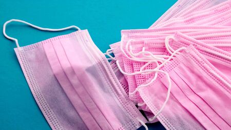 A close-up on pink medical masks on a green backgroundの写真素材