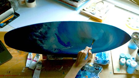 A hand of a woman who is painting in her workshop