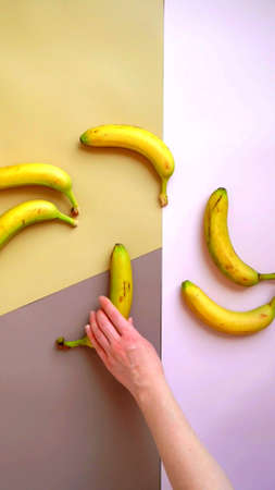 Photo of the hand of a woman who is taking a bananaの写真素材