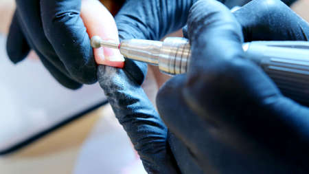 A photo on the hands during a manicure session for the nails