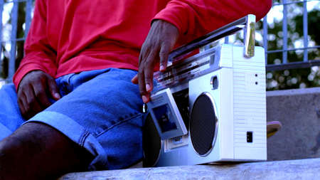 A photo of a black man who is using a vintage radioの写真素材