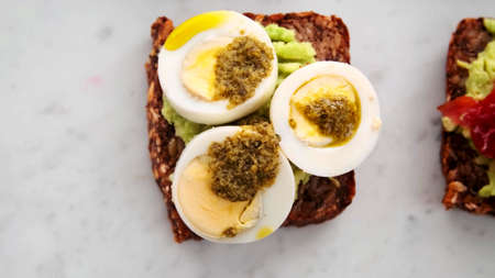 A top view of a sandwich of black bread with eggs