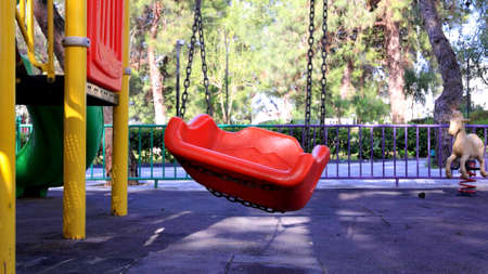 A red swing in a playground
