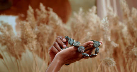 African hands which are holding a traditional necklace