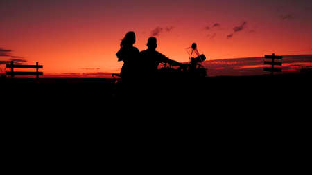 A background photo with a couple on a motorbikeの写真素材