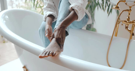 Close-up on a black foot on a bathtub