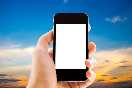 hand holding phone with sky backgroundの写真素材