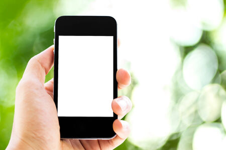 hand holding phone with nature backgroundの写真素材