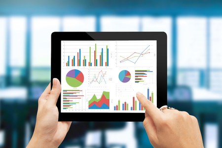 Close-up of male hands touching  tablet with business diagramの写真素材