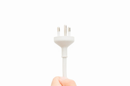 hand holds Electric plug. Isolated on a white background.