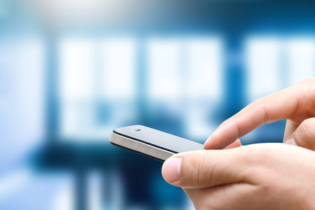 closeup of man hand using smartphone in officeの写真素材