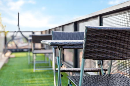 wicker chair  and a table on an open terrace with blue skyの写真素材