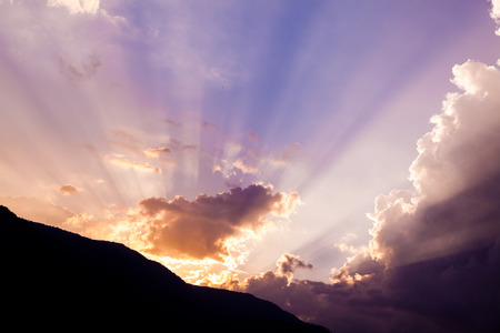 Beautiful dramatic sky with sun rays. over mountain