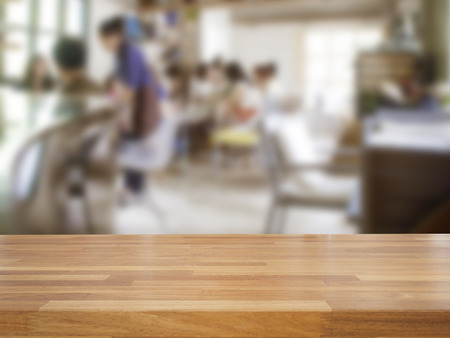 Empty wooden table and blurred people in cafe background, product displayの写真素材