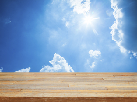 Empty wooden table with blue sky and cloud product displayの写真素材