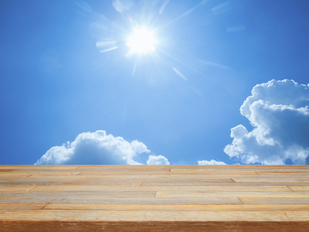 Empty wooden table with blue sky and cloud product displayの写真素材