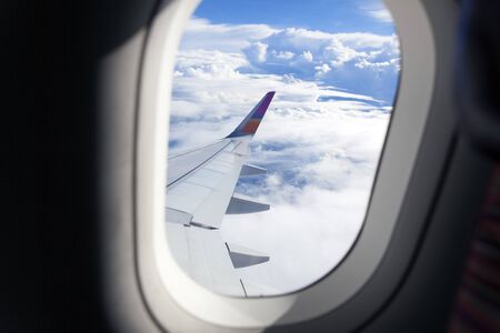 Airplane wing out of window and beautiful cloudの写真素材