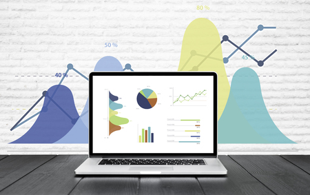 Laptop on wooden table showing charts and graph colorful graphics, Analysis Business Accounting, Statistics Concept.の写真素材