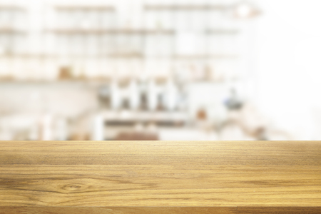 Beautiful empty wooden table and white modern kitchen cafe background, restaurant. Ready for product montageの写真素材