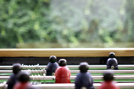 Background of foosball table soccer, inred color, football table in depth of field.の写真素材