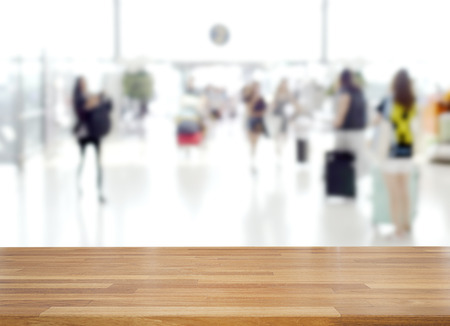 Empty wooden and table on abstract blur people walking in terminal at airport background, product display, Ready for product montageの写真素材