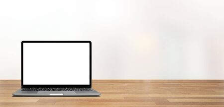Modern blank screen laptop on wooden table  against office with white wall and windows indoor backgroundの写真素材