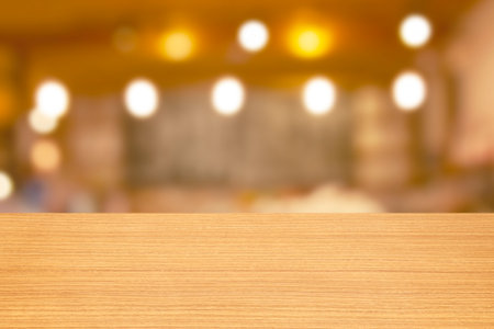 Empty wood table top and blur cafe or restaurant background with bokeh image.の写真素材