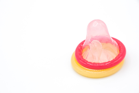 Pink and yellow condom on white background, Having safe sex for Valentine's Dayの写真素材