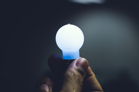 Man hand holding a light bulb with creativity ideas concept, vintage styleの写真素材