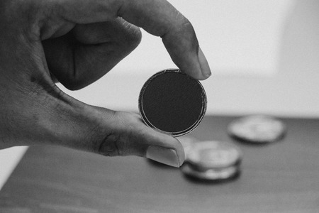 Man's hand holding golden coin, Black and white photography