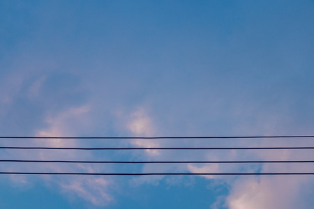 Electric wires on blue sky at eveningの写真素材