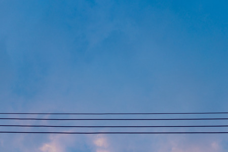 Electric wires on blue sky at eveningの写真素材