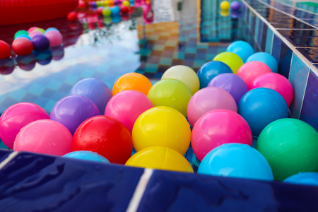 Many colorful plastic balls floating on water surface in poolの写真素材
