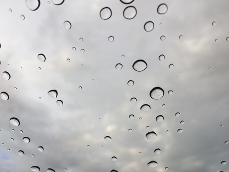 Rain drops on car front window in rainy dayの写真素材