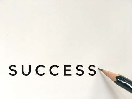 dark green pencil on white paper with success wordingの写真素材