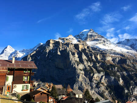 Beautiful white cloud with blue sky on top of Stone Mountain and white snow covered in the afternoon beside village on the hill.の写真素材