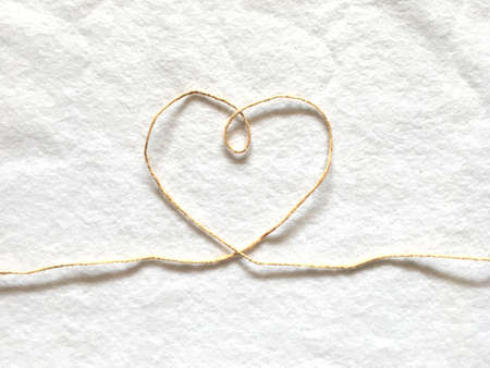 Heart shape made from hemp rope on softness cotton white background. A concept of love.の写真素材