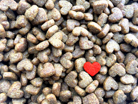 Dry biscuits food for cat with heart shape. Concept of pet lover background.