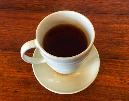 white cup of tea on a wooden table backgroundの写真素材