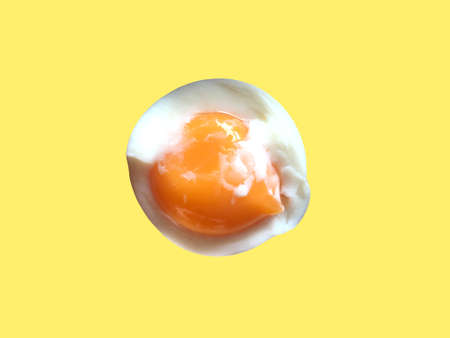 Soft boiled egg with yolk isolated on light yellow backgroundの写真素材